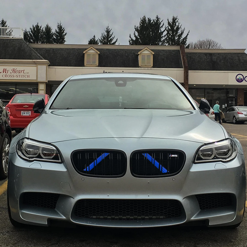 Manos colocando la tira de moldura en la rejilla de un BMW G20