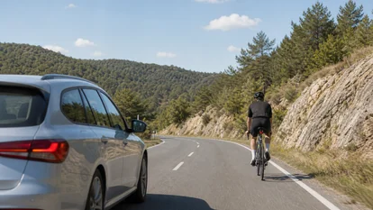 Coche adelantando a un ciclista en carretera secundaria con distancia lateral segura.